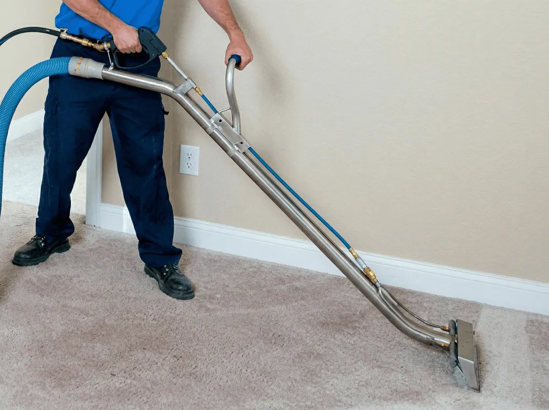 Professional operating a liquid removal machine on a carpeted floor in Huntsville, AL